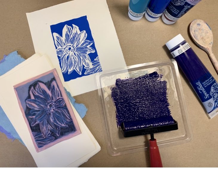 Blue print of flower with carved lino block and roller with paint
