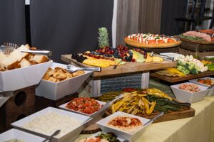 a two-tiered display of food including pizza, fruit, and dips
