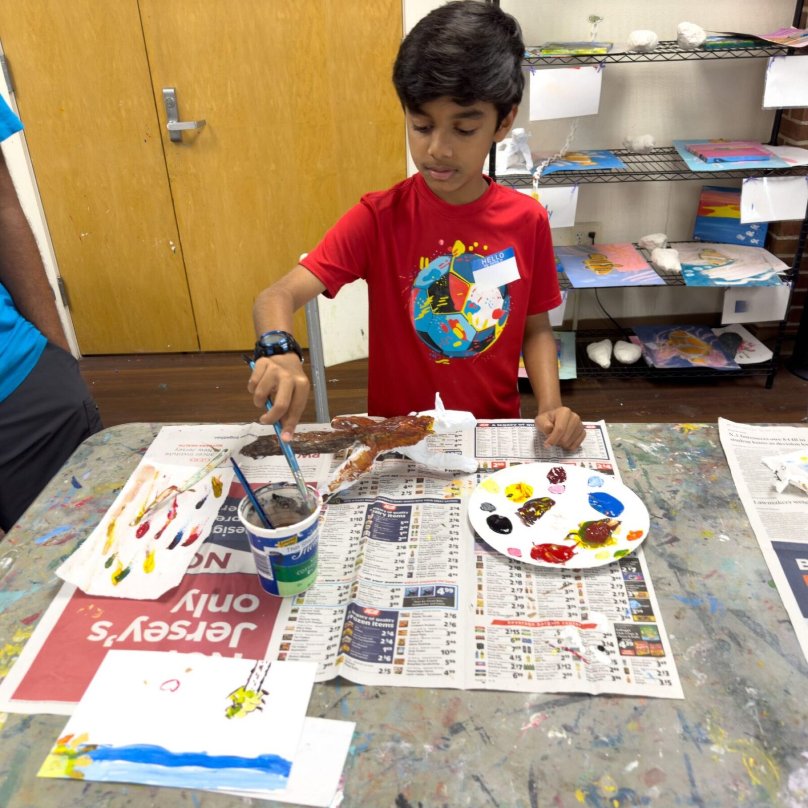 Boy painting a paster wrap sculpture