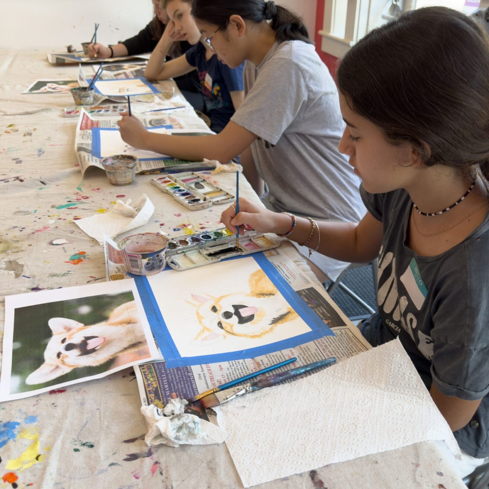 3 students making watercolor paintings of corgi