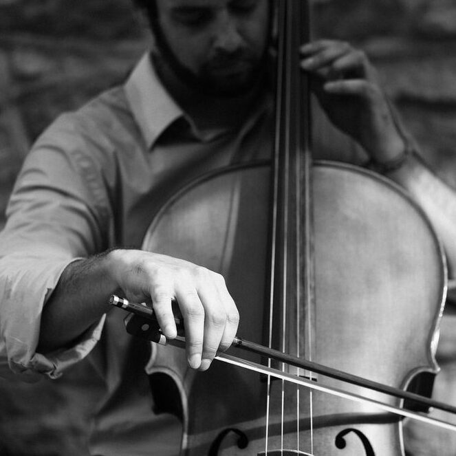 Black and white photo of a man playing a cello